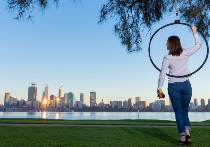 girl with lyra holding juggling balls at skyline